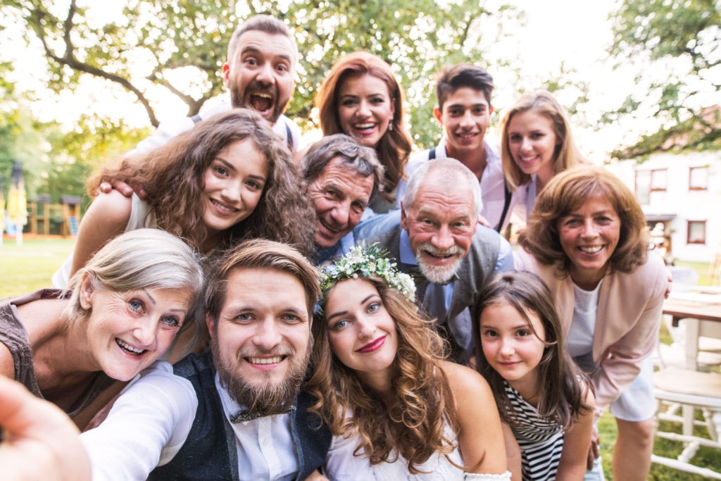 Bride, groom with guests taking a selfie at the wedding reception.