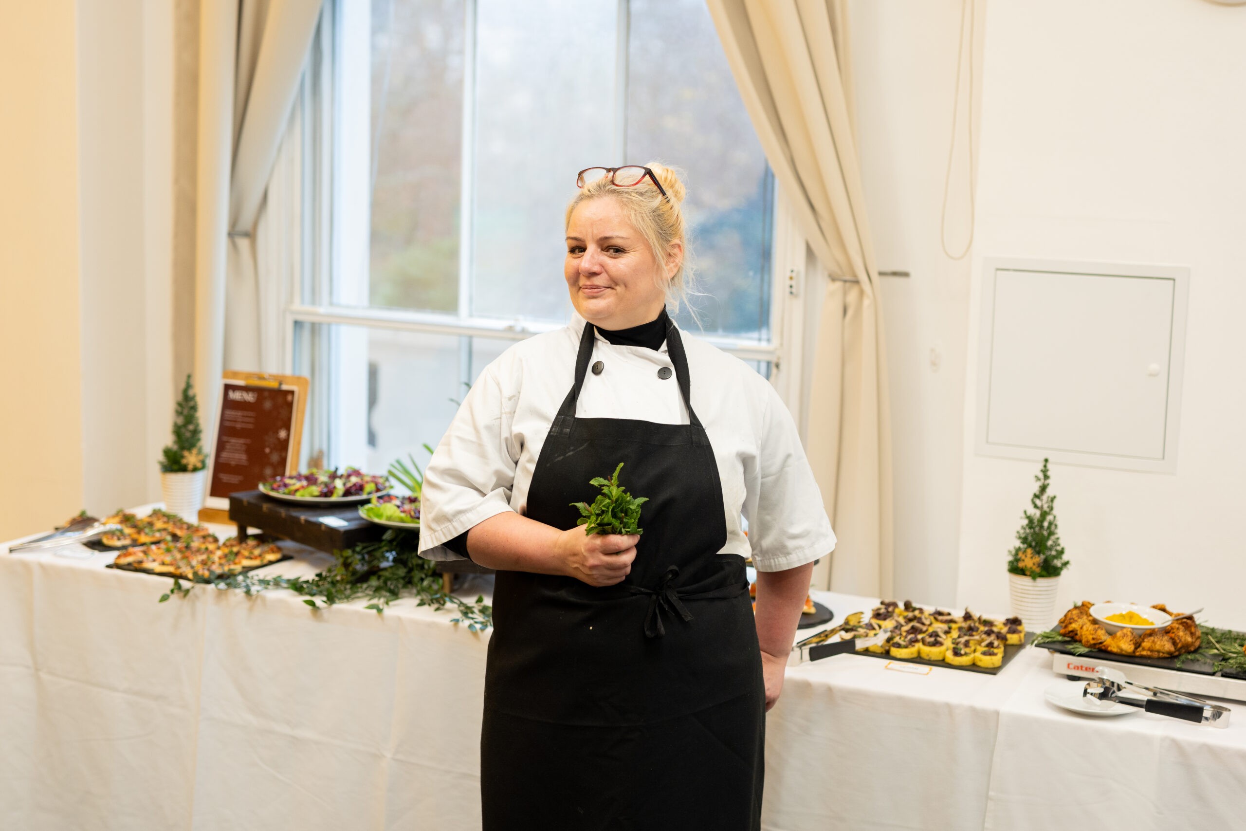 Catering chef with food setup on a table behind
