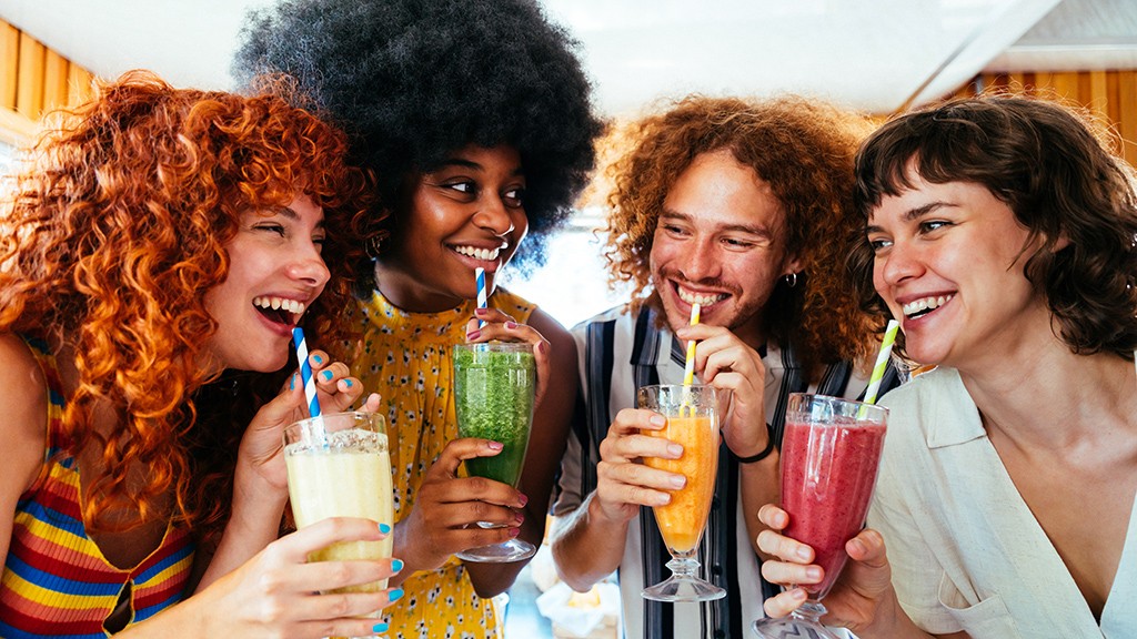Multiethnic group of friends drinking vegan smoothies