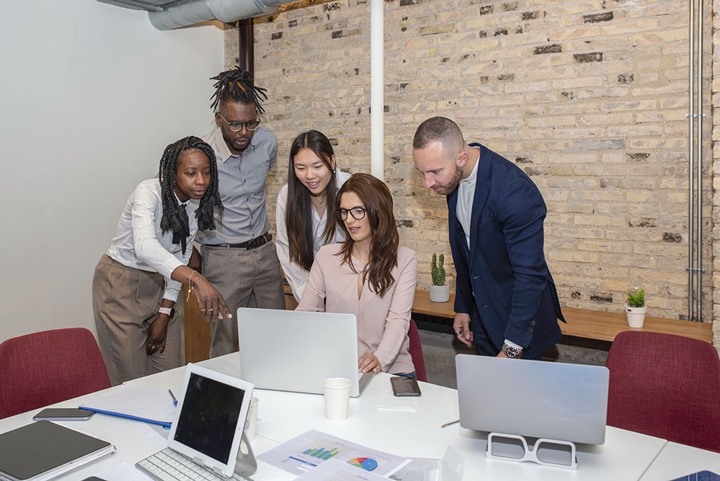 coworkers around a desk discussing new ideas and strategies of their project
