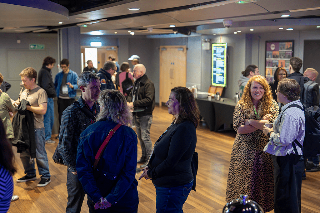 people networking at an event in venue 2 with refreshments in the background