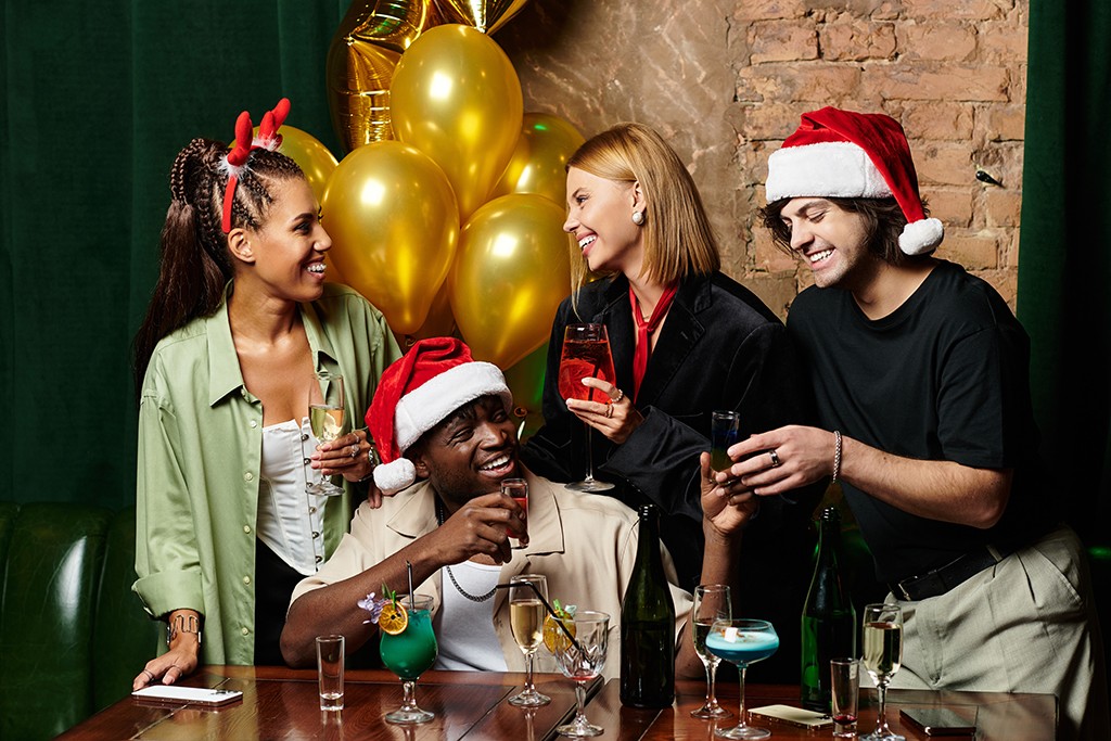 Young professionals savour festive drinks and camaraderie at a joyful corporate event.