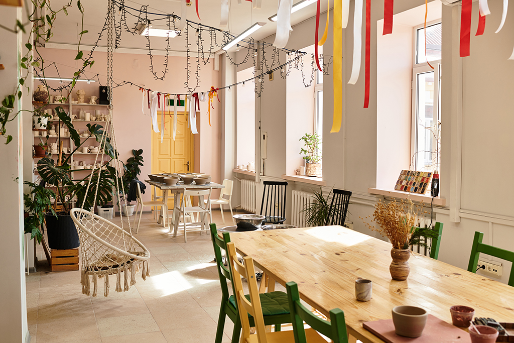 A lively pottery studio filled with handmade ceramics, colorful decor, and communal crafting areas.