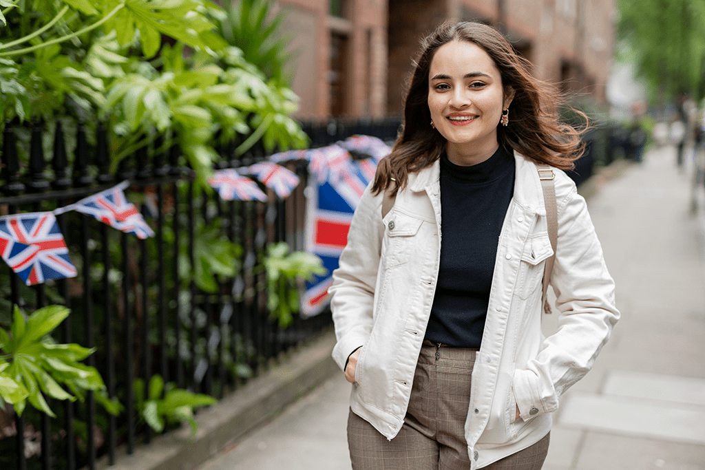 woman walking along a London street with Union Jack flags in the back