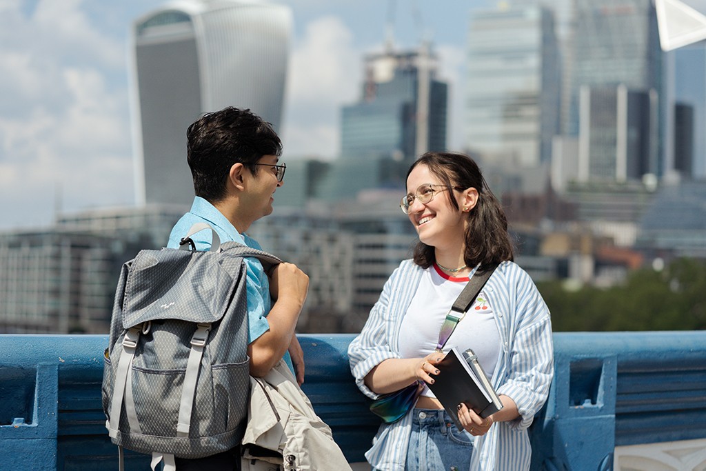 man and woman talking with London skyline in the background
