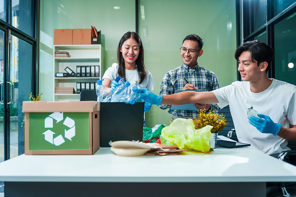 Team discusses waste management strategies at desk, separating plastic waste.