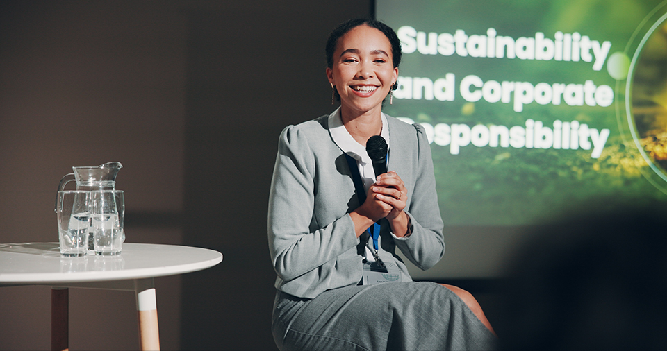 Woman, stage and happy at conference for sustainable ideas  and responsible corporate decisions.