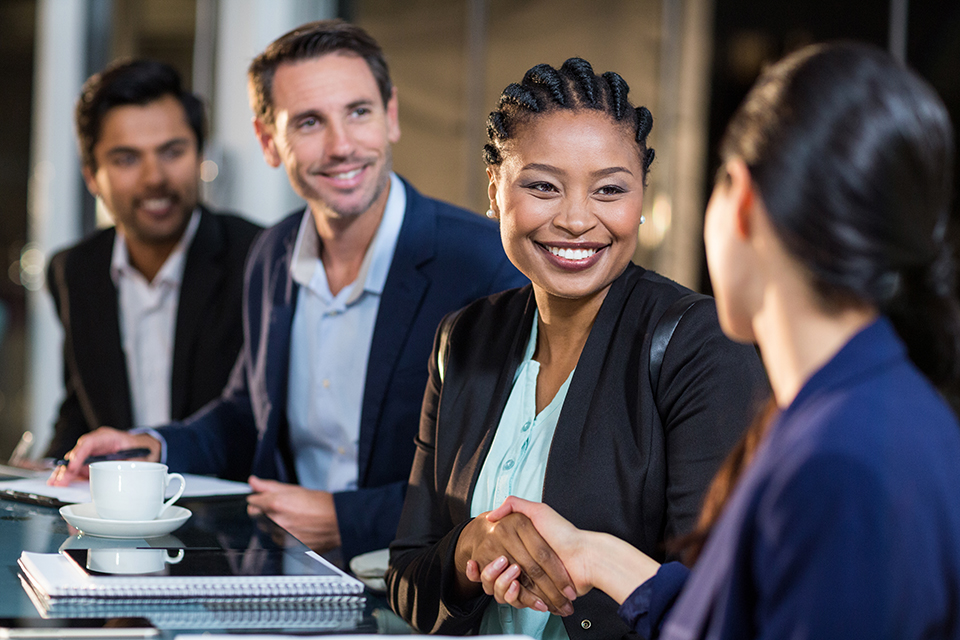 Businesswoman shaking hands with colleague at networking event