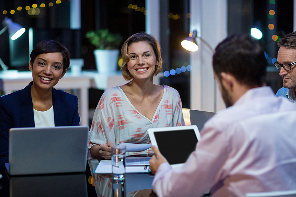 Smiling Businesspeople Networking In Office At Night